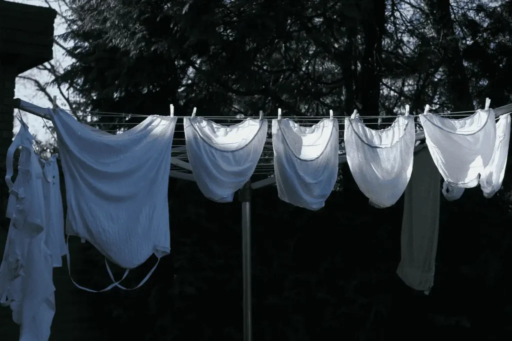 Cloth diapers and laundry hanging on a clothesline outdoors to sun out stains naturally